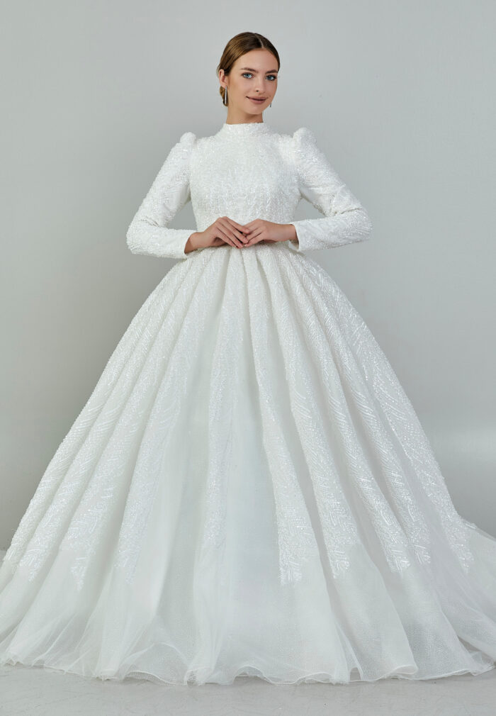Bride wearing a high-neck long sleeve ball gown with hand-beaded detailing and cathedral train from Casa Reina Bridal Collection