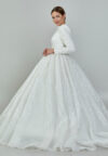 Bride wearing a high-neck long sleeve ball gown with hand-beaded detailing and cathedral train from Casa Reina Bridal Collection