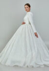 Bride wearing a high-neck long sleeve ball gown with hand-beaded detailing and cathedral train from Casa Reina Bridal Collection