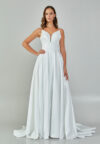 Bride wearing a minimalist satin A-line gown with plunging neckline and structured waist from Casa Reina Bridal Collection