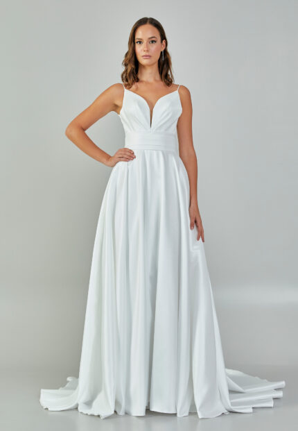 Bride wearing a minimalist satin A-line gown with plunging neckline and structured waist from Casa Reina Bridal Collection