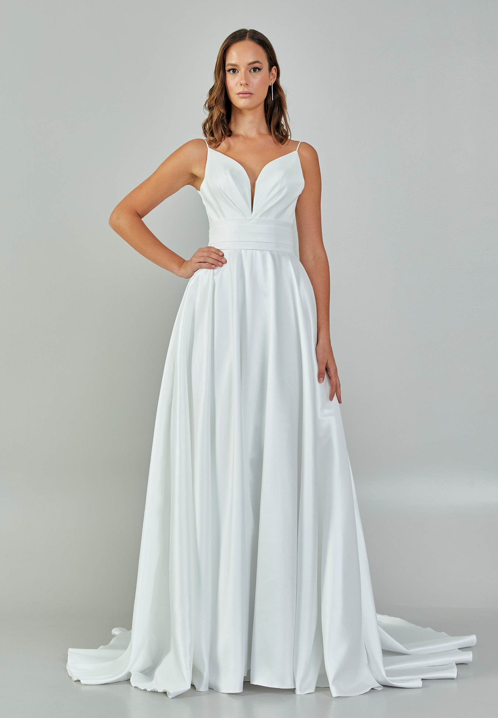 Bride wearing a minimalist satin A-line gown with plunging neckline and structured waist from Casa Reina Bridal Collection