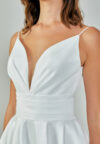 Bride wearing a minimalist satin A-line gown with plunging neckline and structured waist from Casa Reina Bridal Collection