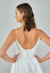 Bride wearing a minimalist satin A-line gown with plunging neckline and structured waist from Casa Reina Bridal Collection